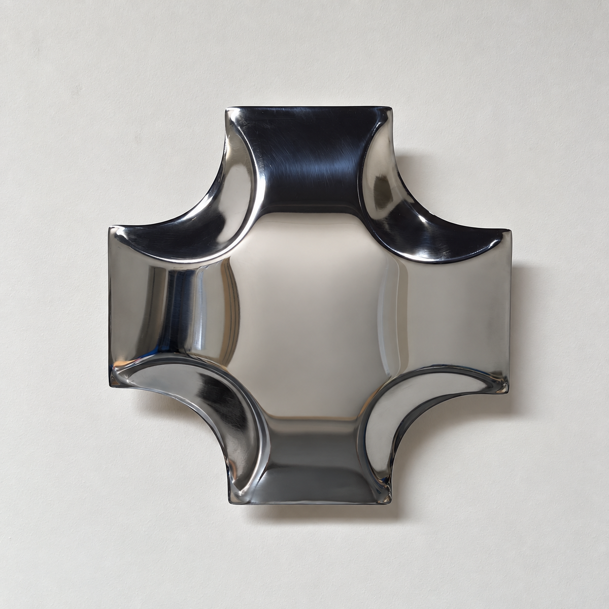 Quadra Wall Sculpture — mirror-finish stainless steel quatrefoil cross wall decor by AERIS LIVING