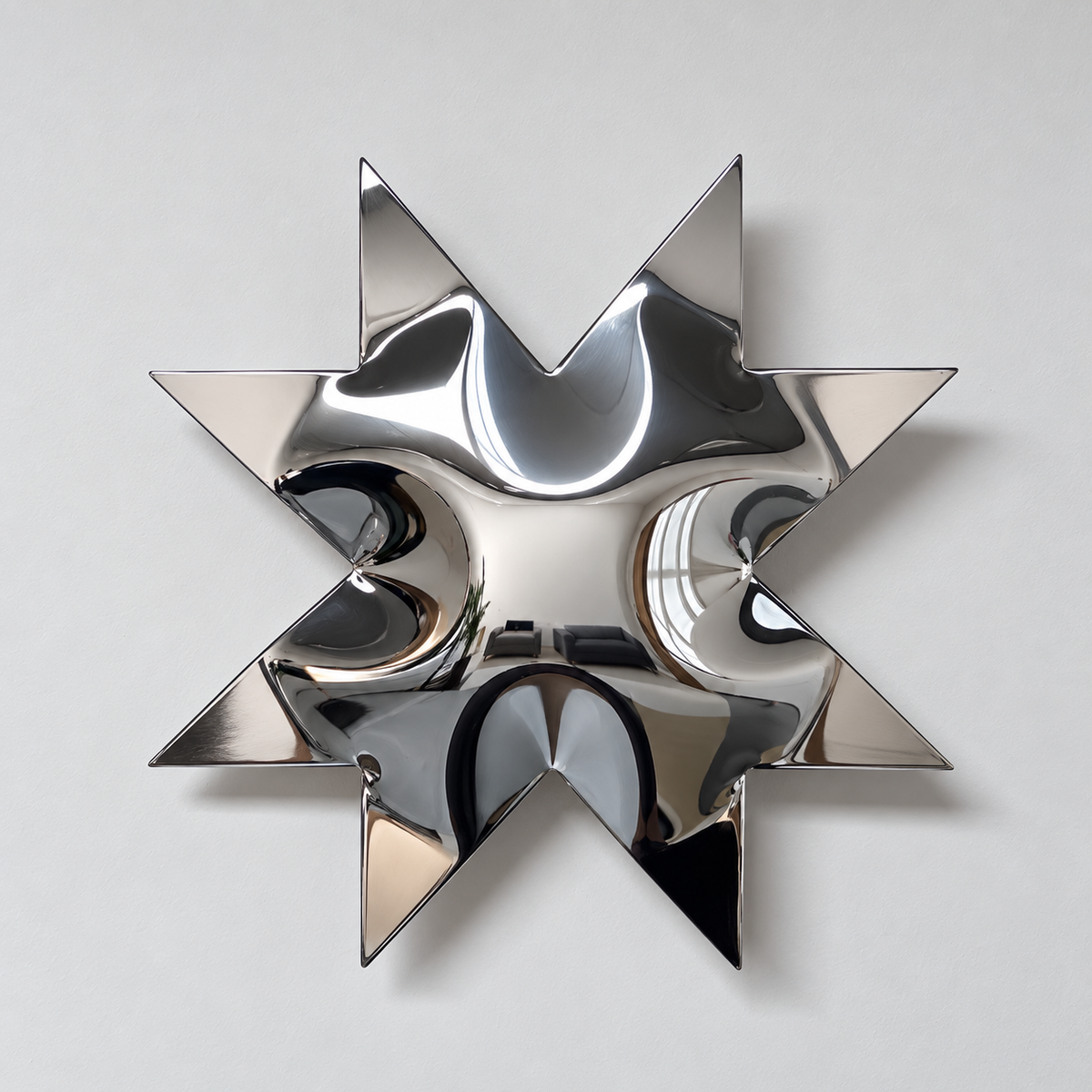 Solara Wall Sculpture — mirror-finish stainless steel eight-point star wall decor by AERIS LIVING